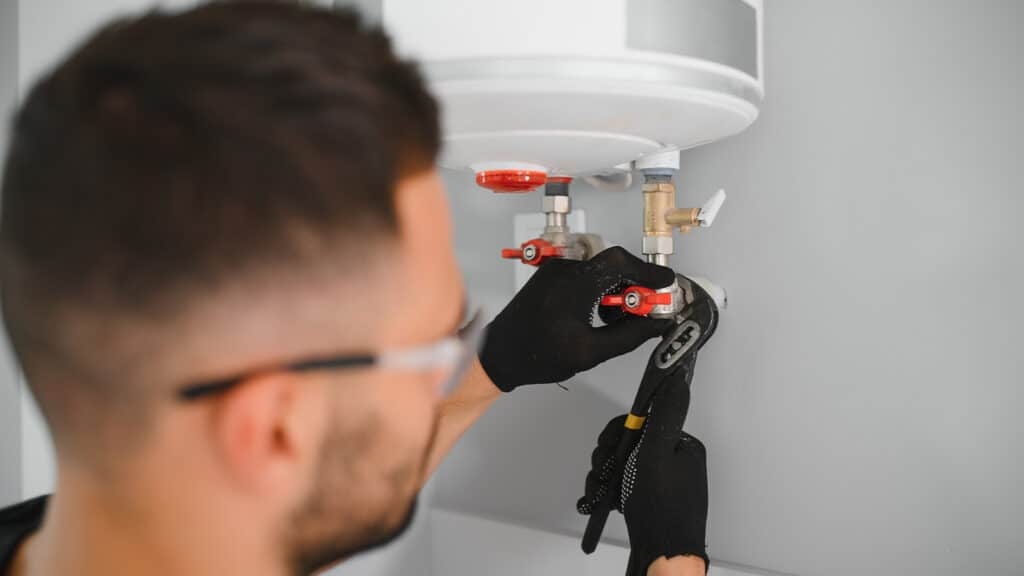 Man repairing a boiler with a wrench